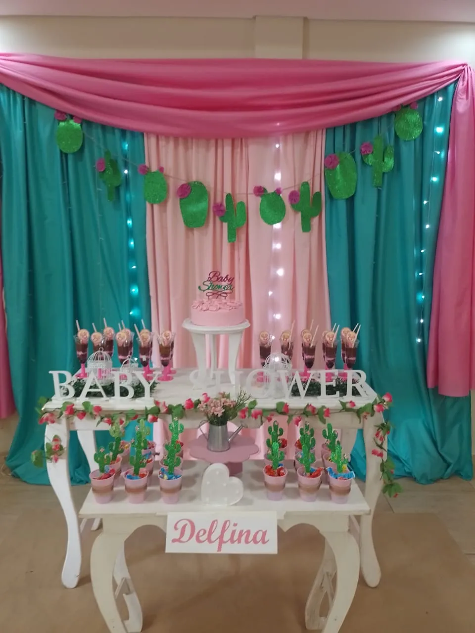 Mesa dulce con cortinas rosa y turquesa y guirnalda de cactus